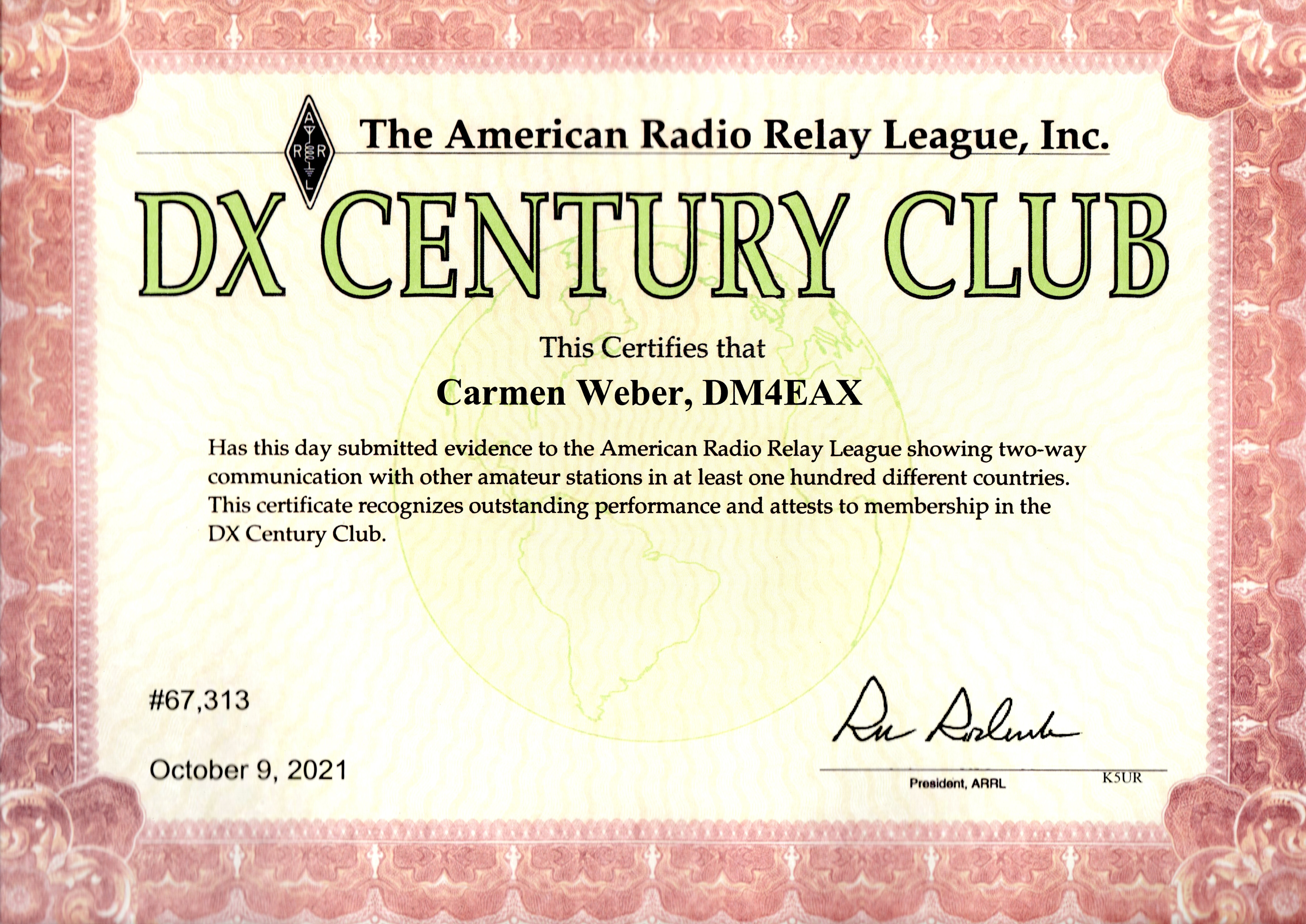 1) Kurzbeschreibung: Diplom der American Radio Relay League Inc. mit großem Titel „DX CENTURY CLUB“ in Grün und dekorativem, rotem Rahmen.

2) Ausführliche Beschreibung: Das Foto zeigt das Diplom „DX CENTURY CLUB“ der American Radio Relay League, Inc. Über einem Textblock steht als Empfänger des Diploms „Carmen Weber, DM4EAX“. Im unteren Teil steht links die Nummer „#67,313“ und das Datum „October 9, 2021“. Rechts gibt es eine Unterschrift, darunter „President, ARRL“ und „K5UR“. Ein dekorativer, roter Rahmen umfasst die Diplomurkunde.
