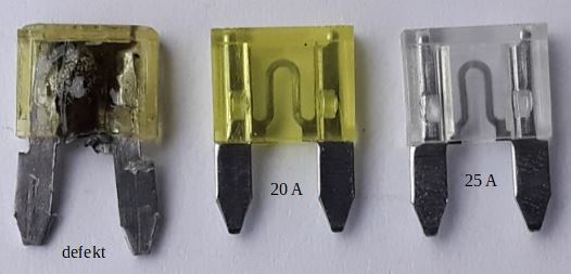 Der folgende Alt-Text wurde noch nicht geprüft: 1. Kurze Zusammenfassung: Drei Stecksicherungen liegen nebeneinander auf weißem Untergrund: links eine stark beschädigte, in der Mitte eine gelbe mit Aufdruck 20 A und rechts eine transparente mit Aufdruck 25 A.

2. Detaillierte Beschreibung: Das Foto zeigt drei flache Kfz‑Stecksicherungen in einer Reihe von links nach rechts. Die linke Sicherung wirkt angeschmort: Das transparente Gelb ist dunkel verfärbt, das Gehäuse teils aufgeschmolzen, innen sind schwarze Rußspuren zu sehen; darunter steht klein „defekt“. Die mittlere Sicherung ist klar gelbtransparent, ihr U‑förmiger Leiter ist gut erkennbar, die beiden Zungen sind sauber, darunter steht „20 A“. Die rechte Sicherung ist farblos transparent, ebenfalls mit sichtbarem U‑Leiter und sauberen Metallzungen, darunter steht „25 A“. Alle drei liegen flach auf einer glatten, hellen Oberfläche, die Beleuchtung kommt von oben und wirft weiche Schatten.