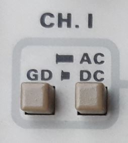 Dieser Alt-Text wurde noch nicht überprüft.

1) Zusammenfassung: Ausschnitt eines hellgrauen Geräte-Bedienfelds mit der Aufschrift „CH. I“, zwei quadratischen Tasten und den Beschriftungen „GD“, „AC“ und „DC“.

2) Detaillierte Beschreibung: Oben steht in dunkler Schrift „CH. I“. Darunter befindet sich ein hellgrau umrandeter Kasten mit abgerundeten Ecken. Im unteren Bereich des Kastens sind zwei beige, quadratische Drucktasten nebeneinander angeordnet. Über der linken Taste steht „GD“, daneben ein kleines schwarzes Balkensymbol. Über der rechten Taste steht links neben „AC“ ein kleines schwarzes Balkensymbol; darunter, rechtsbündig, „DC“. Hintergrund und Rahmen sind hellgrau, Schrift und Symbole dunkelgrau; sonst keine weiteren Elemente sichtbar.