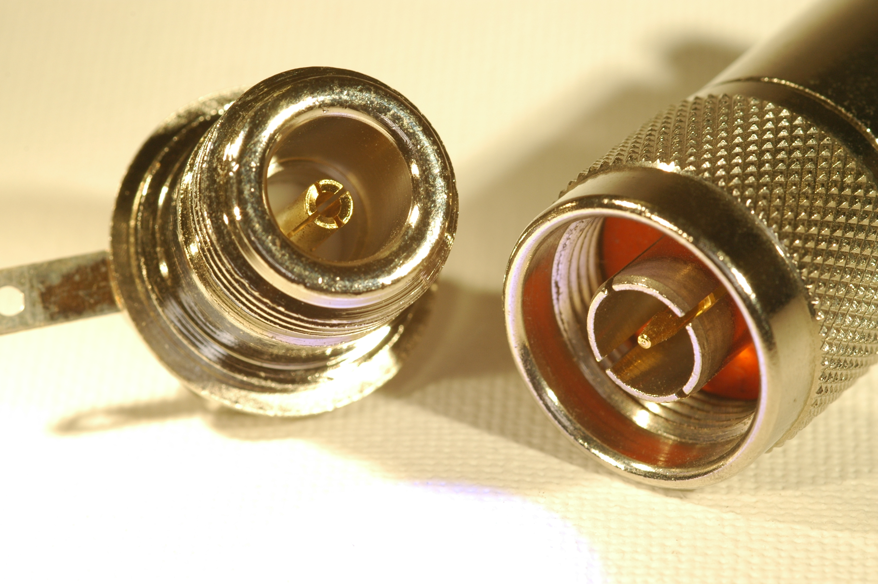 1) Kurzbeschreibung: N-Einbaubuchse (links) und N-Stecker (rechts).

2) Ausführliche Beschreibung: Das Foto zeigt links eine N-Einbaubuchse mit Außengewinde und rechts den zugehörigen N-Stecker mit einer gerändelten Hülse mit Innengewinde und einem Mittelstift im Inneren, umgeben von einem geschlitzten Zylinder und einem orangefarbenen Isolator.